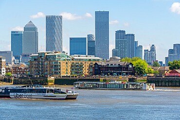 View of Canary Wharf Financial District and taxi boat from the Thames Path, London, England, United Kingdom, Europe