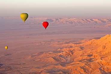 Hot air balloons suspended over the Theban hills of Luxor and the Valley of the Queens at sunrise, Thebes, UNESCO World Heritage Site, Egypt, North Africa, Africa