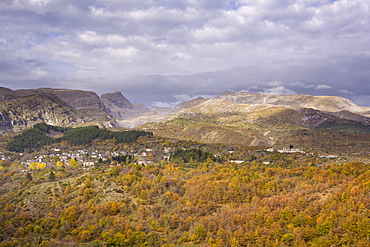 A little sunlight breaks through on a cloudy day above Tsepelovo and the Timfi mountain range, Epirus, Greece, Europe