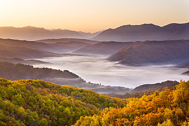 Looking down onto the little Zagorian village of Kipi on a misty morning in Autumn, just after sunrise, Epirus, Greece, Europe