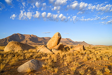 Boulders on the plains below the Brandberg mountain range at sunrise, Damaraland, Namibia, Africa