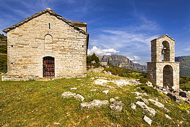 Ancient church on the edge of the semi abandoned village of Ano Klidonia in Zagoria, with the Astraka peaks in the distance, Epirus, Greece, Europe