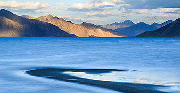 The turquoise, saline water of Tso Pangong, backed by mountains in the evening sun, Ladakh, India, Asia