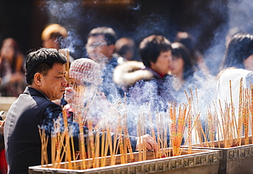 People burning incense outside Wong Tai Sin Temple, Kowloon, Hong Kong, China, Asia