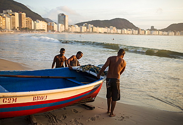 Fishermen taking their boat out at dawn, Copacabana, Rio de Janeiro, Brazil, South America