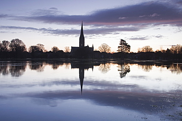 Salisbury cathedral at dawn reflecting in the flooded West Harnham Water Meadows, Salisbury, Wiltshire, England, United Kingdom, Europe