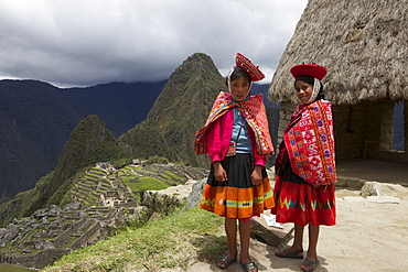 Traditionally dressed children looking over the ruins of Machu Picchu, UNESCO World Heritage Site, Vilcabamba Mountains, Peru, South America