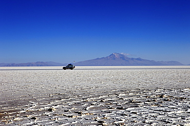 A 4x4 on Salar de Uyuni, the largest salt flat in the world, South West Bolivia, Bolivia, South America