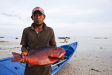 Fisherman showing a fish - Grogos Island Maluku Indonesia