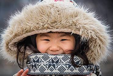 Korean teenager in Seoul street in winter, wearing a hat