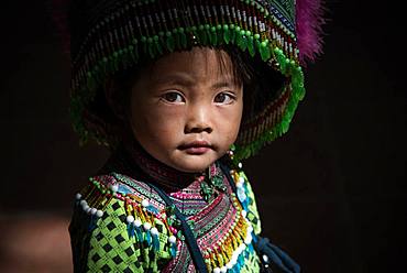 Vietnamese girl at Sapa covered market in Northern mountains. She is dressed in the traditional clothes of Hmong flowers.