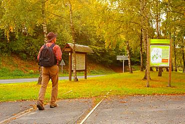 Walker walking on a green stream following an old abandoned railway line connecting Beauvais to Amiens - in autumn, Picardy, France.