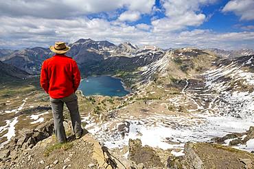 Hiker on the Tours du Lac, Lake Allos (2226 m) and in the background Mont Pelat (3051m), Haut-Verdon, Mercantour National Park, Alps, France