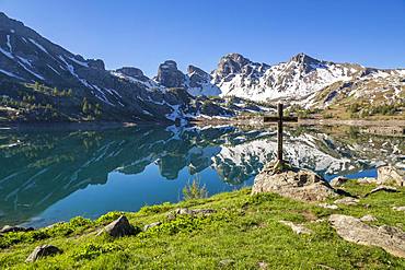 Wooden cross on the shore of Lake Allos (2226 m), in the background the Tours du Lac, Haut-Verdon, Mercantour National Park, Alps, France