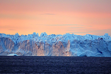 Serac at sunset, a huge serac of a hundred meters long and 30 meters high has just detached from a glacier front at the bottom of Scoresby Sund, It will break into several large icebergs, Greenland