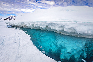 The top of the iceberg emerges from the frozen sea surface, it moves up and down according to the tide and keep the water free around it. Tasiilaq, East Greenland