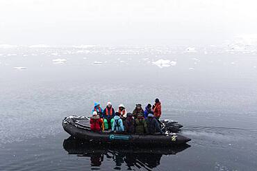 Tourist in inflatable boat, Wilhelmina Bay, Antarctica.