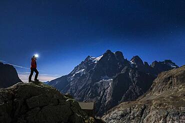 Mount Pelvoux (3932m) and the Pelvoux glacier illuminated by a full moon night, hiker at the Glacier Blanc refuge (2580m), Vallouise valley, Brian?onnais region, Ecrins National Park, Hautes-Alpes, France