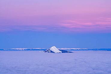 Mole Mountain emerges from a sea of clouds at morning twilight. Shooting from the Flaine station. Haute-Savoie, France In the background, the Jura chain.