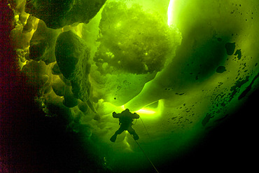 Scuba diver under ice and ice formation, Arctic circle Dive Center, White Sea, Karelia, northern Russia