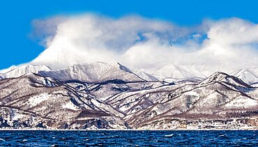 Hokkaido island coastline with hills, beautiful clouds, sky and sea. Japan. Sea of Okhotsk. Kunashir Strait.