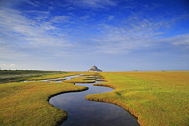 Mont-Saint-Michel from a polder and its winding channel, Manche, Normandy, France