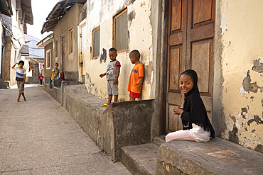 Children playing in narrow streets, little girls wearing headdresses, Stone Town, capital of Zanzibar, Tanzania