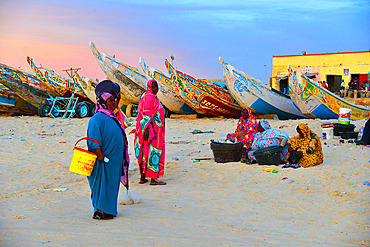 Women in melhfa waiting for the return of the fishermen near the fish market of Nouakchott. Nouakchott. Mauritania.