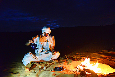 Mauritanian travel guide making tea at night at a camp in the desert. Chinguetti. Ancient ksour of Ouadane, Chinguetti, Tichitt and Oualata. Adrar. Mauritania