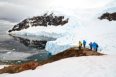 Passangers walking in the snow at Neko Harbour. Cruise on board Exploris One. Antarctic.