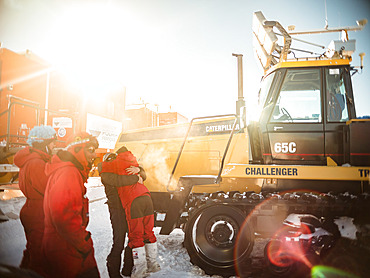 Tractor parked in front of the Raid caravan. Two technicians hug each other. The Raid supplies the resort 2 or 3 times each summer. A one-way trip represents a distance of 1,200km, an altitude difference of 3,200m, and a driving time of 10 days at a rate of 12 hours per day. Each arrival of the Raid team at Concordia is a moment of joy and celebration. Concordia Antarctic Research Station, Dome C plateau, East Antarctica.