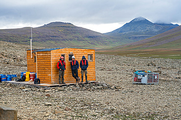 The team waits for the helicopter to load the last crate of equipment, weighing just under a ton. Phonolite hut. Ronarc'h peninsula, Kerguelen archipelago.