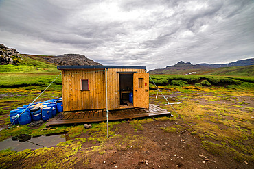 The Riviere du Nord hut. Composed of two small wooden modules solidly braced to the ground. One is the kitchen, the other the dormitory. Outside, cans contain enough food for a team of three or four scientists to live in for several weeks. Kerguelen Archipelago