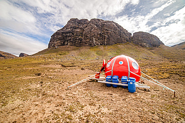 The Port Elisabeth shelter is a spartan little sphere, solidly guyed to the ground because of the strong winds. The blue cans contain food for several people and several weeks. Kerguelen Archipelago