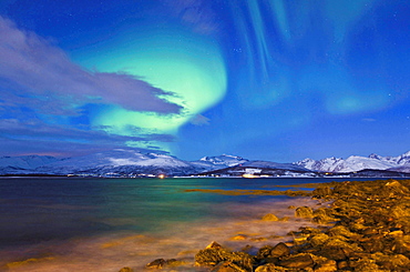 meteorology northern lights over landscape coast with mountains snow covered sky with stars