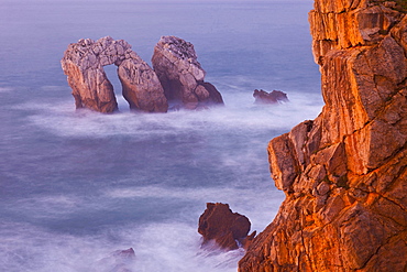 group of rocks forming gate near rocky coast of sea long exposure Los Urros Province Cantabria Cantabrian Sea Spain Europe