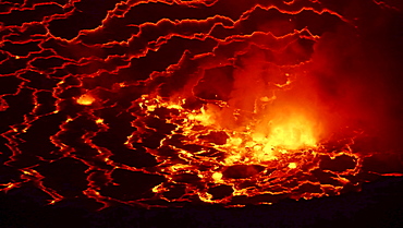 volcano Nyiragongo crater with lava fountains in the lava lake rising smoke nature natural phenomenon night view Kongo Afrika