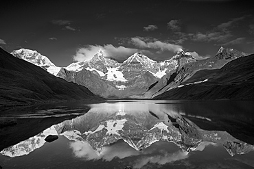 Andes mountains mountain Yerupaja 6635 m and Yerupaja Chico 6121 m partially covered with snow mountain lake in front with water surface reflection sunrise natural mood