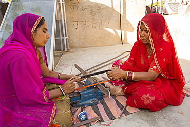 Women constructing solar cookers at the Barefoot College in Tilonia, Rajasthan, India. The Barefoot College is a worldwide charity, founded by Bunker Roy, its aims are, education, drinking water, electrification through solar power, skill development, health, women empowerment and the upliftment of rural people.