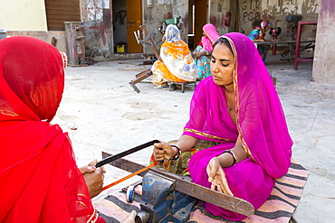 Women constructing solar cookers at the Barefoot College in Tilonia, Rajasthan, India. The Barefoot College is a worldwide charity, founded by Bunker Roy, its aims are, education, drinking water, electrification through solar power, skill development, health, women empowerment and the upliftment of rural people. The use of the cookers, vastly reduces the amount of fire wood women have to go out and collect from the forest.