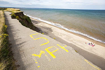 A collapsed coastal road at Barmston on Yorkshires East Coast, near Skipsea, UK. The coast is composed of soft boulder clays, very vulnerable to coastal erosion. This sectiion of coast has been eroding since Roman times, with many villages having disappeared into the sea, and is the fastest eroding coast in Europe. Climate change is speeding up the erosion, with sea level rise, increased stormy weather and increased heavy rainfall events, all palying their part.