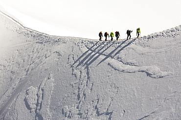 Climbers on the arete leading up from the Vallee Blanche to the Aiguille Du Midi above Chamonix, France.