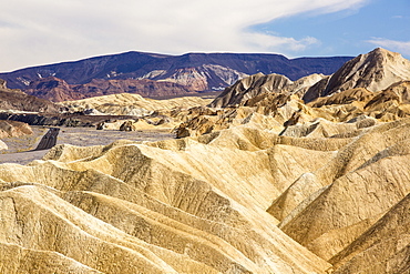 Badland scenery at Zabriskie Point in Death Valley which is the lowest, hottest, driest place in the USA, with an average annual rainfall of around 2 inches, some years it does not receive any rain at all.