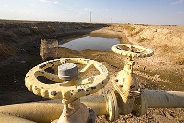 A virtually empty farmers water hole in California's Central Valley, which is in the grip of a four year long drought. The catastrophic drought means that no crops will grow without increasingly scarce irrigation water. Many areas of farmland have been abandoned due to the drought.