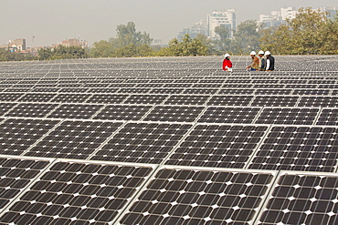 Workers at a 1 MW solar power station run by Tata power on the roof of an electricity company in Delhi, India.