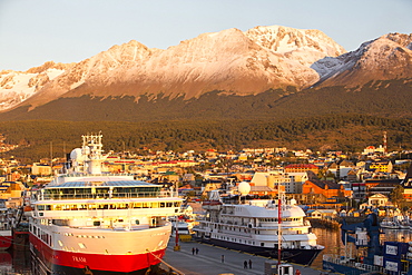 Sunrise over Antarctic expedition ships in the harbour of Ushuaia which is the capital of Tierra del Fuego, in Argentina, it is the most southerly city in the world and the starting point for trips to Antarctica.