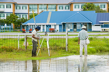 Surveying the floodwater caused by sea water incursion due to global warming induced sea level rise that threatens the future of these low lying islands, Funafuti Atoll, Tuvalu, Pacific