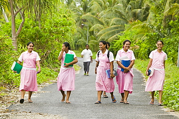 School girls walking home from school on Funafuti Atoll, Tuvalu, Pacific