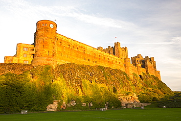 Bamburgh Castle, Northumberland, UK, in glowing light at sunset.