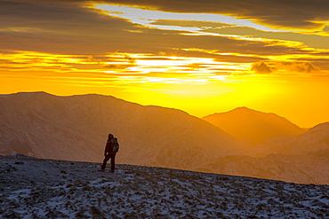 A walker on the summit of Red Screes at sunset in the Lake District, UK, taken on Wednesday 4th February 2015